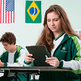 estudante do Bom Jesus segurando um tablet enquanto estuda no Lace